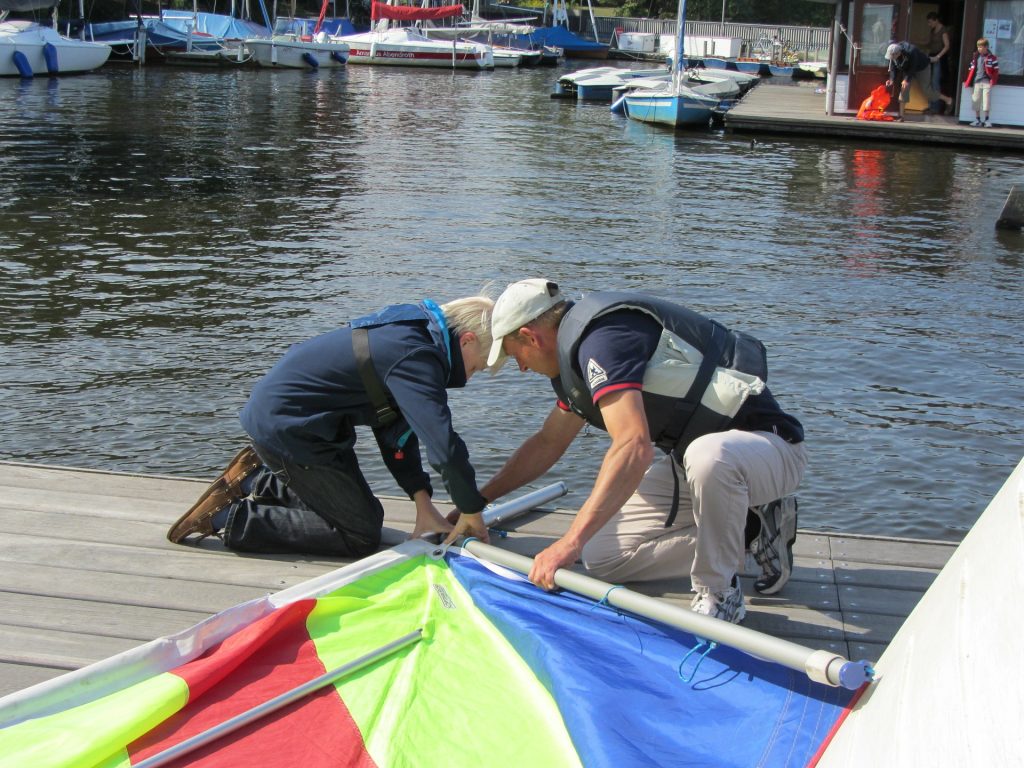 Two people checking their sailing dinghy for safety
